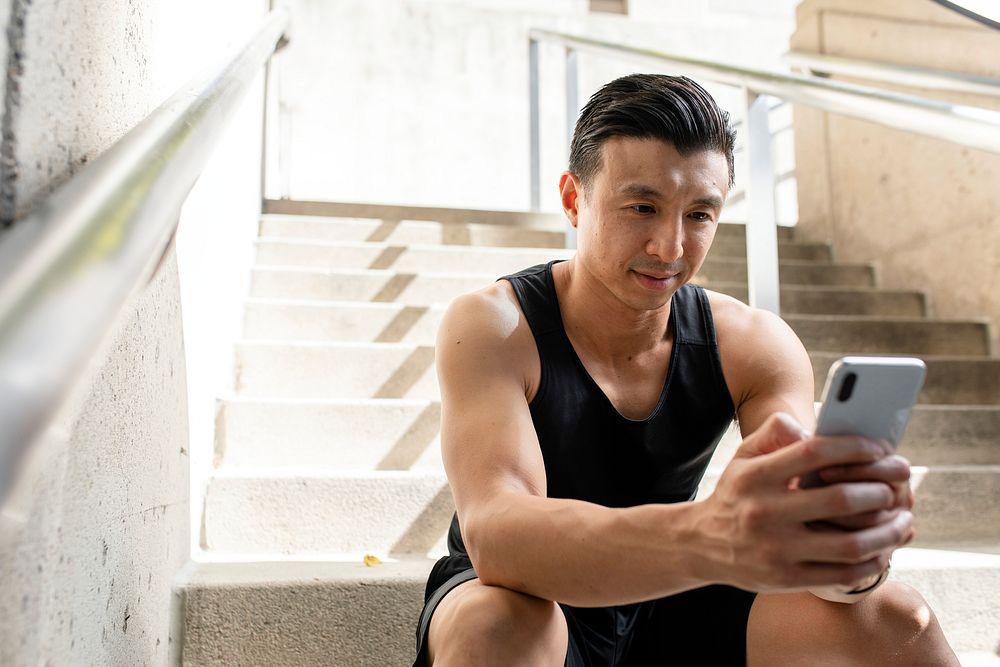 Asian man texting on a phone 