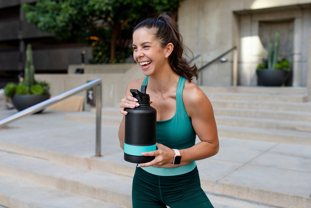 Reusable water bottle mockup psd carried by a happy woman