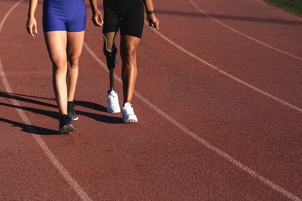 Two athletes walking on a running track 