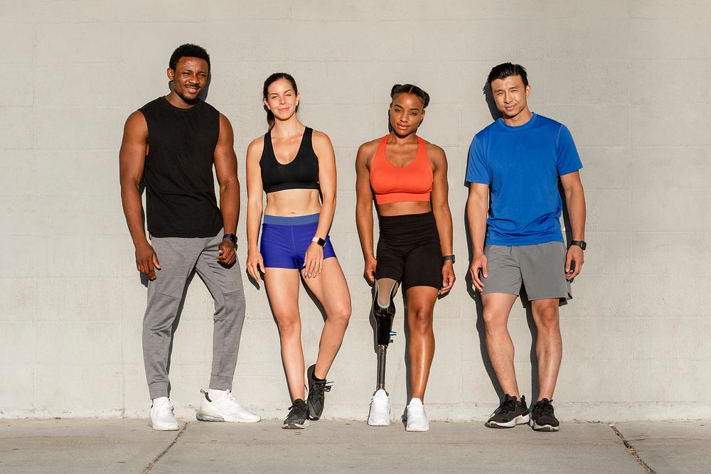 Diverse athletes posing by the wall 
