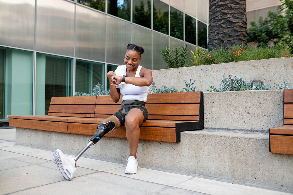 Woman with prosthetic leg looking at her smartwatch 