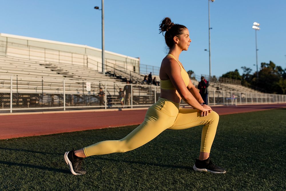 Woman doing yoga for a morning workout by the stadium 