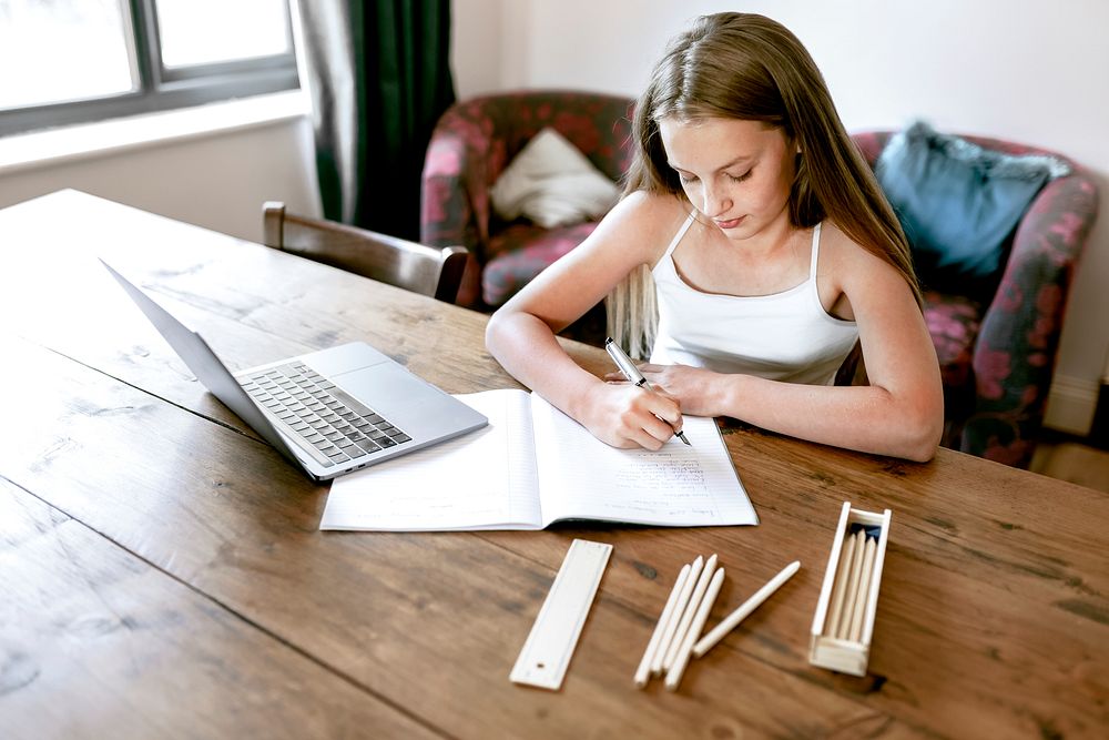 Blond girl having online class, homeschooling in the new normal