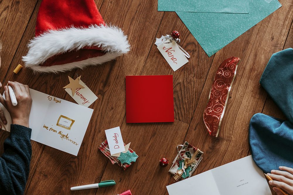 Christmas wishing cards on wooden floor, flat lay
