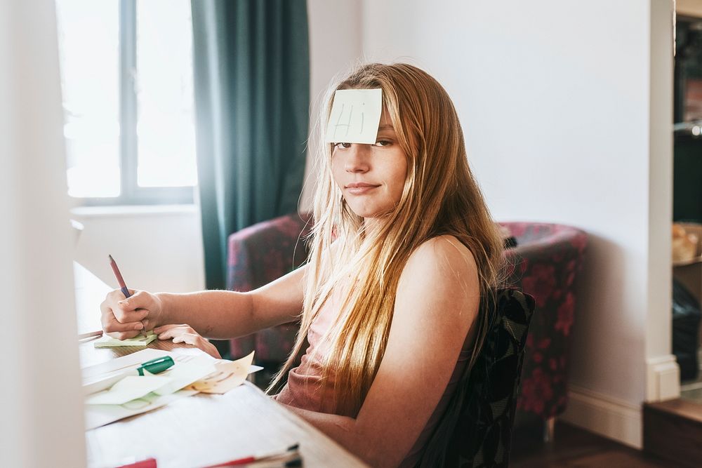 Girl with note paper on forehead, homeschooling in the new normal