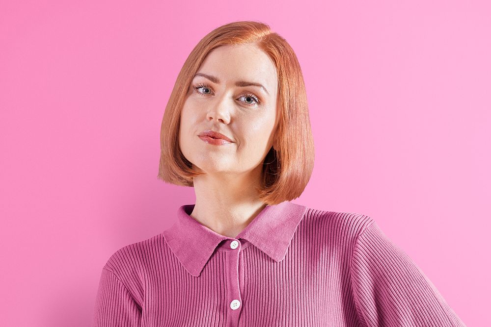 Happy ginger-haired woman in pink knitted shirt