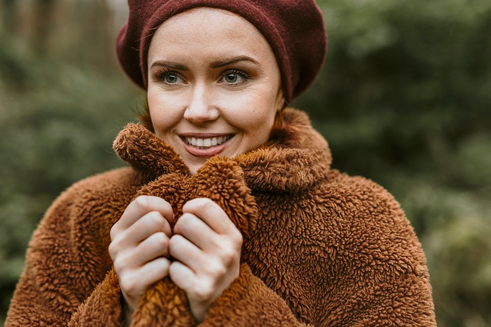 Happy woman wearing brown teddy jacket in cold autumn day