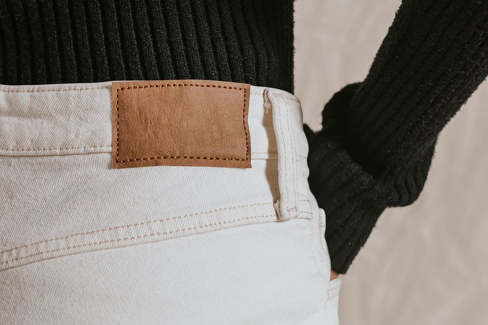 Blank brown leather tag on white jeans