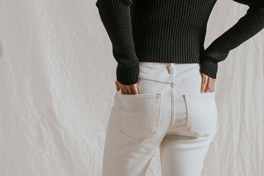 Woman in black sweater and white jeans, rear view