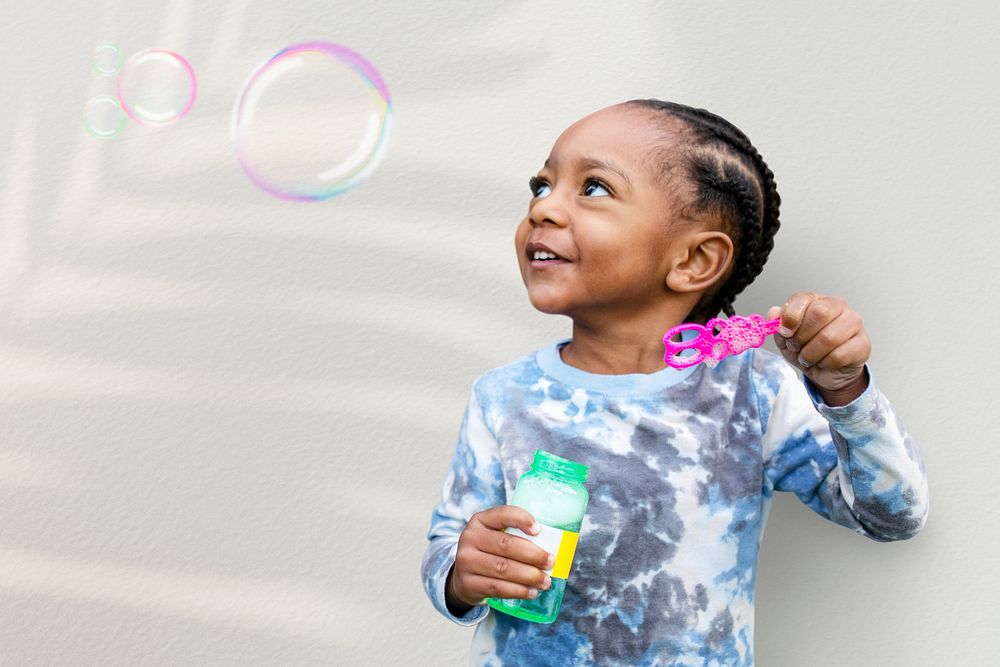 Cute boy blowing soap bubbles in the summer