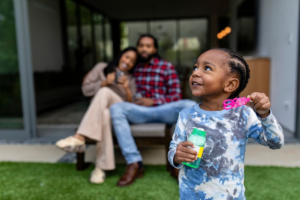 Boy playing in front yard of family home