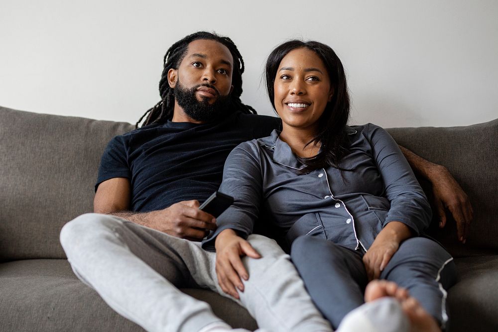Couple watching TV together at home