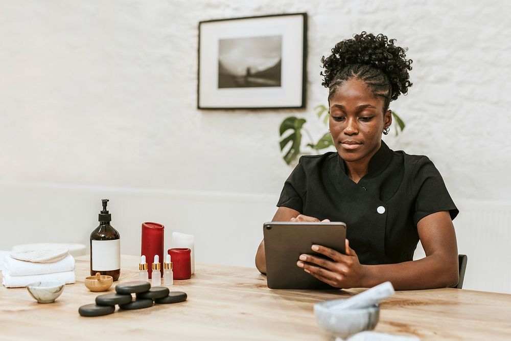 African American spa attendant using tablet for work