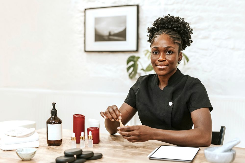 African American woman holding serum bottle in spa