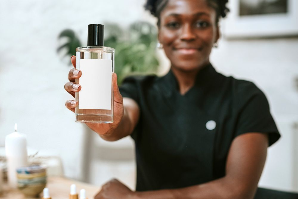 African American woman holding perfume bottle