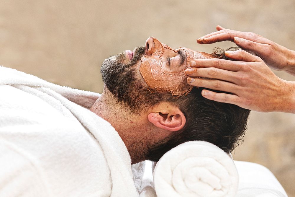 Man relaxing in facial mask spa, self-care photo