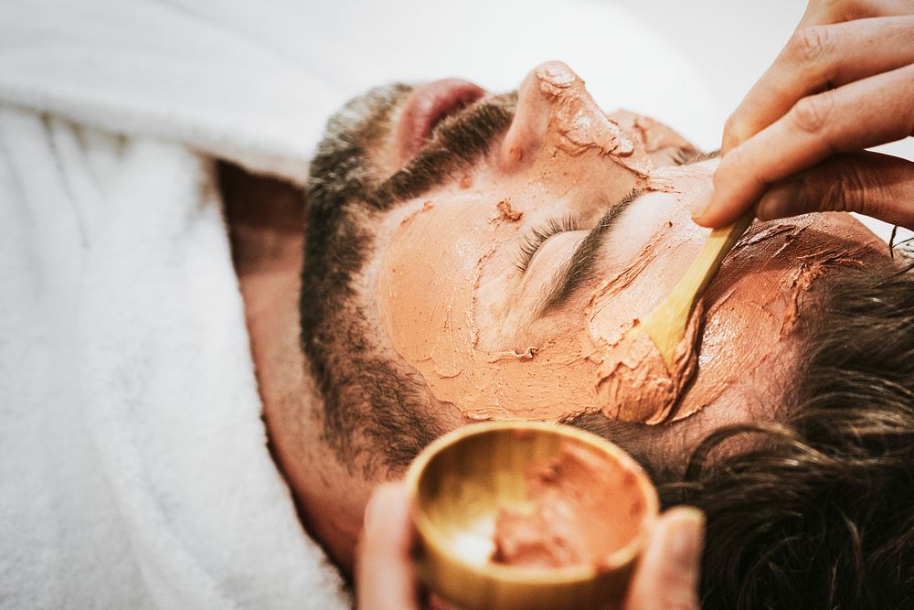 Man getting spa facial mask, self-care photo