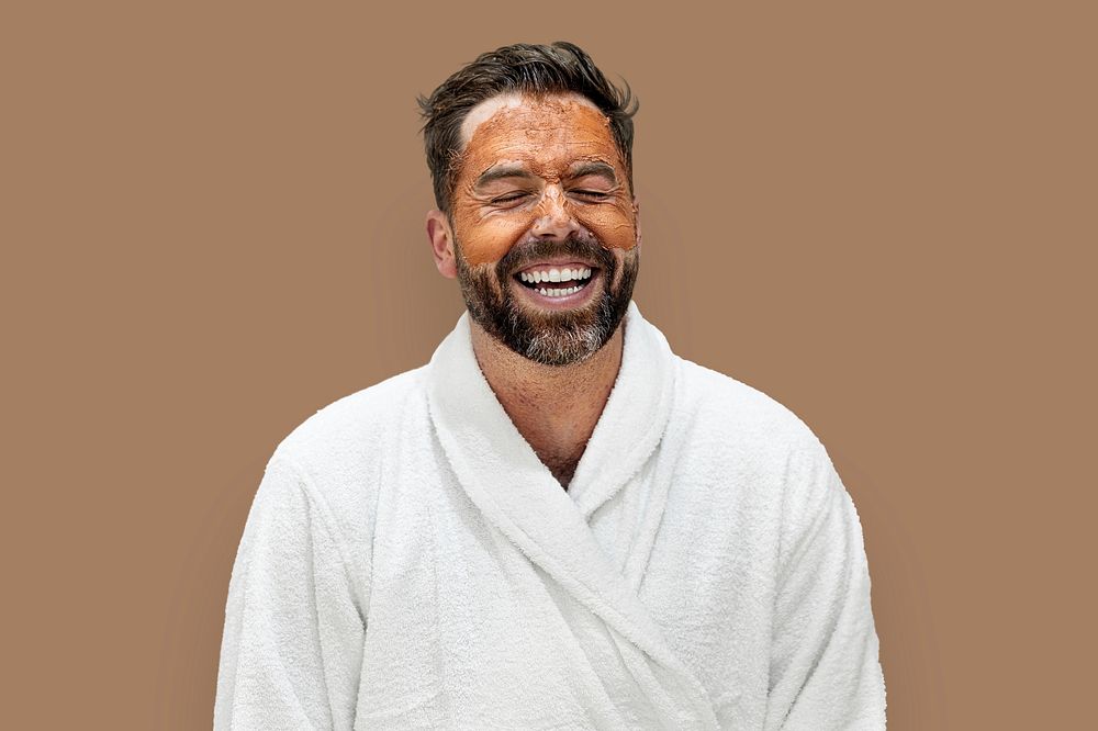 Man wearing bathrobe with facial mask isolated on background