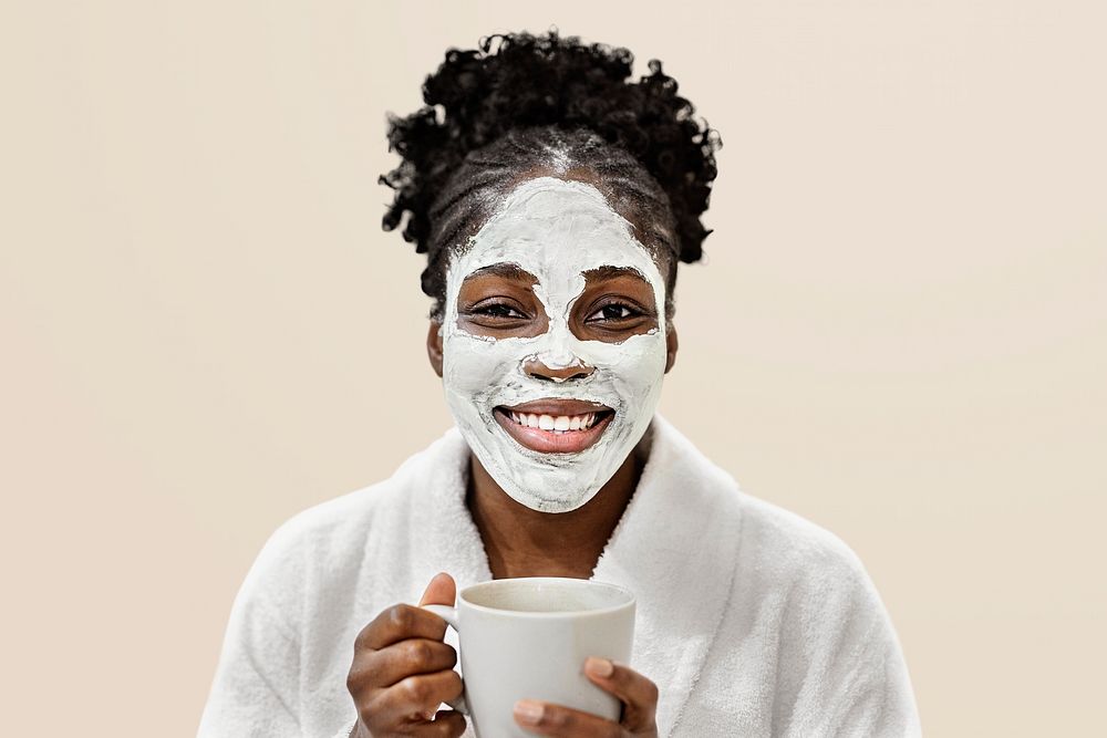 Woman with spa facial mask holding a cup