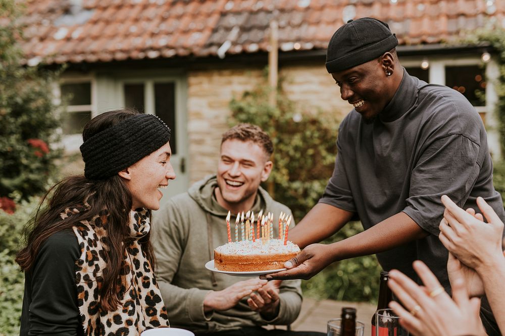 Woman bringing a birthday cake to her birthday friend 