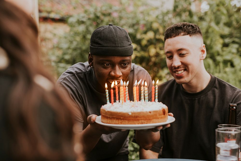 Man blowing candles on top of a birthday cake 
