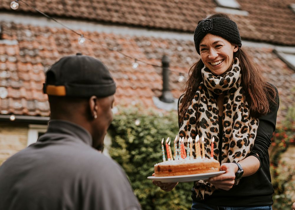 Woman bringing a birthday cake to her birthday friend 