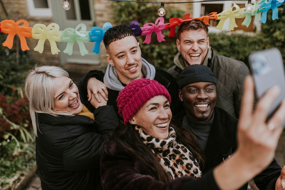 Diverse friends taking a group selfie at a Christmas party 