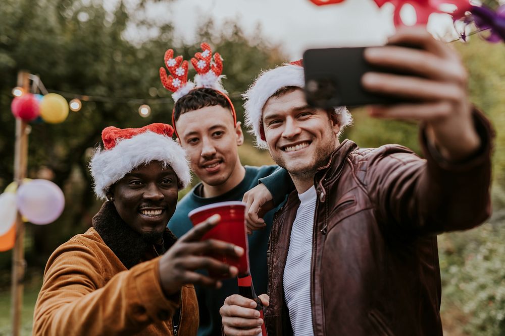 Diverse friends taking a group selfie at a Christmas party 