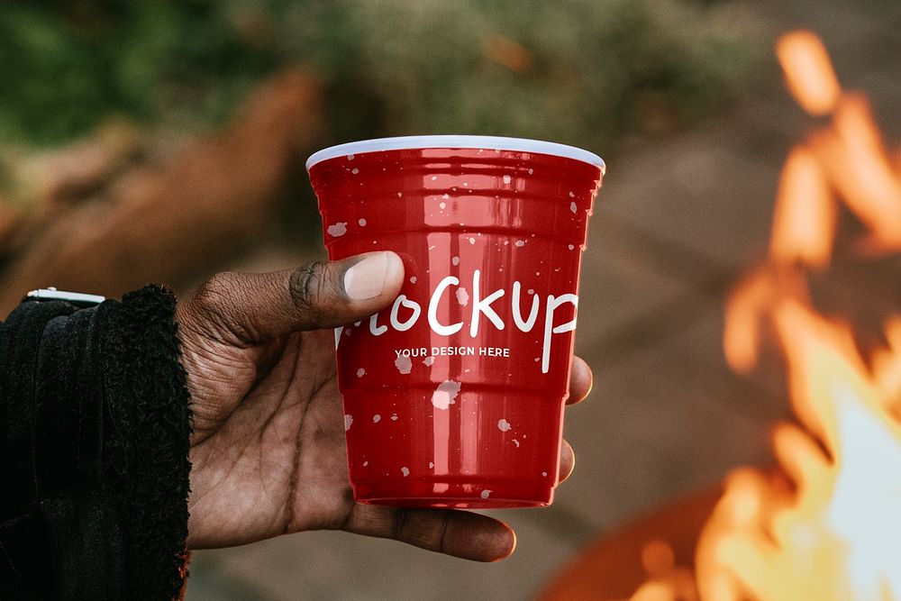 Cup mockup psd being held by a person for toasting