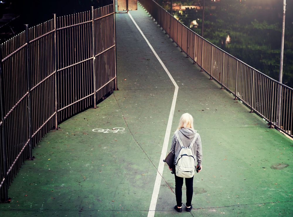A woman walking down a green pathway