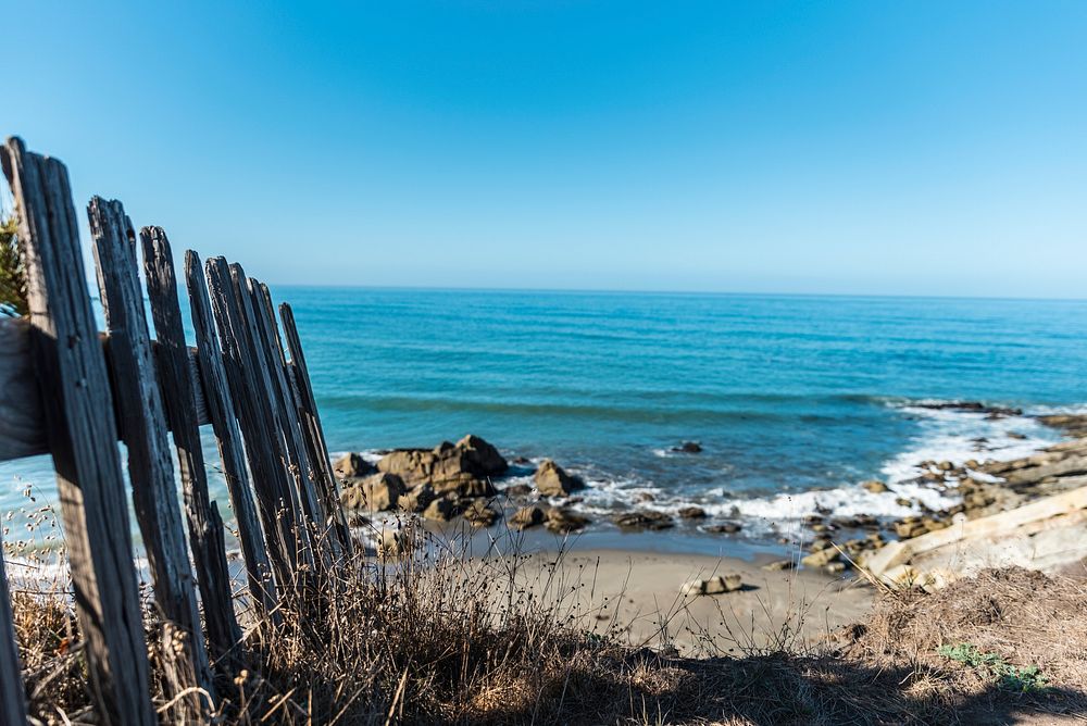 Wooden fence by a rocky beach