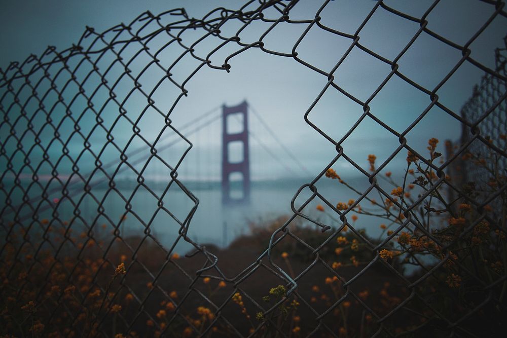 View of the Golden Gate Bridge, San Francisco, United States through a broken wire fence