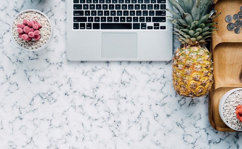 Pineapple next to a laptop