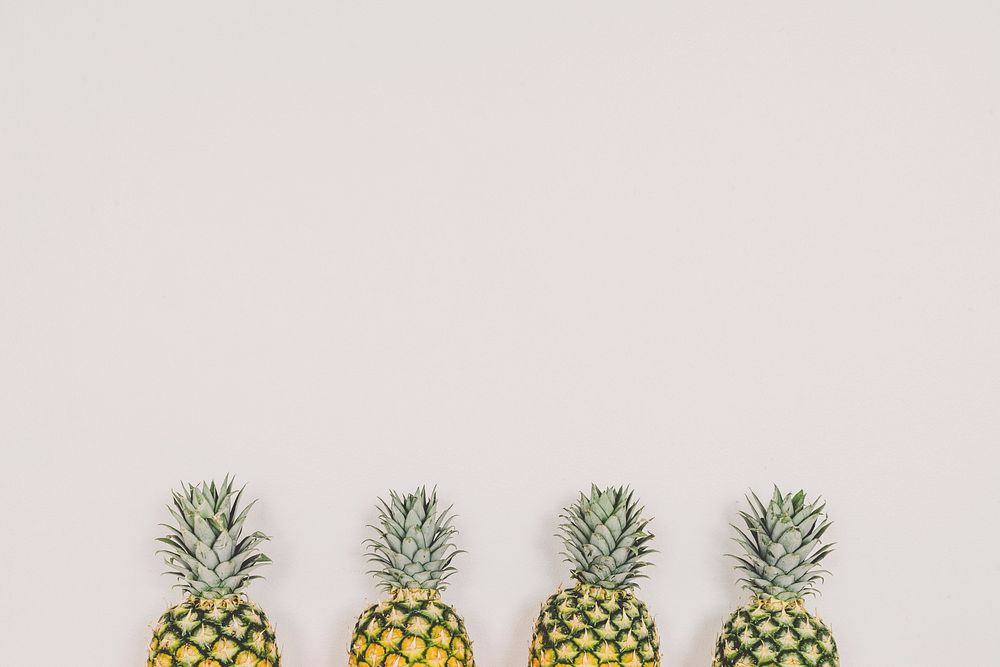 Four ripe pineapples aligned together