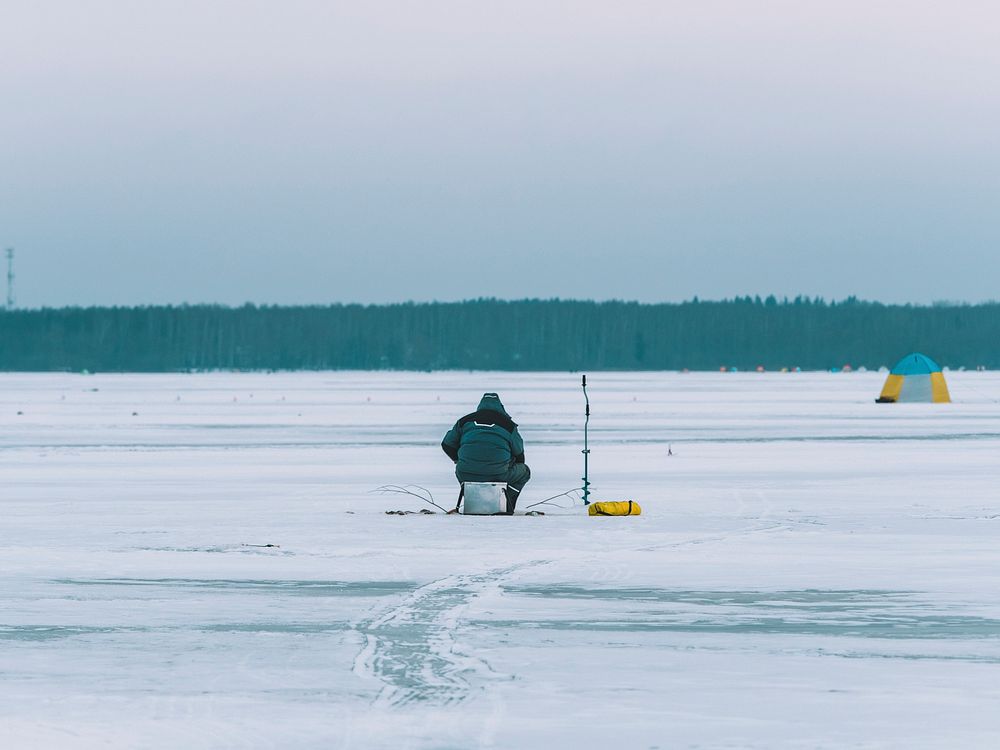 Man fishing on a frozen lake in Mozhaysk, Russia