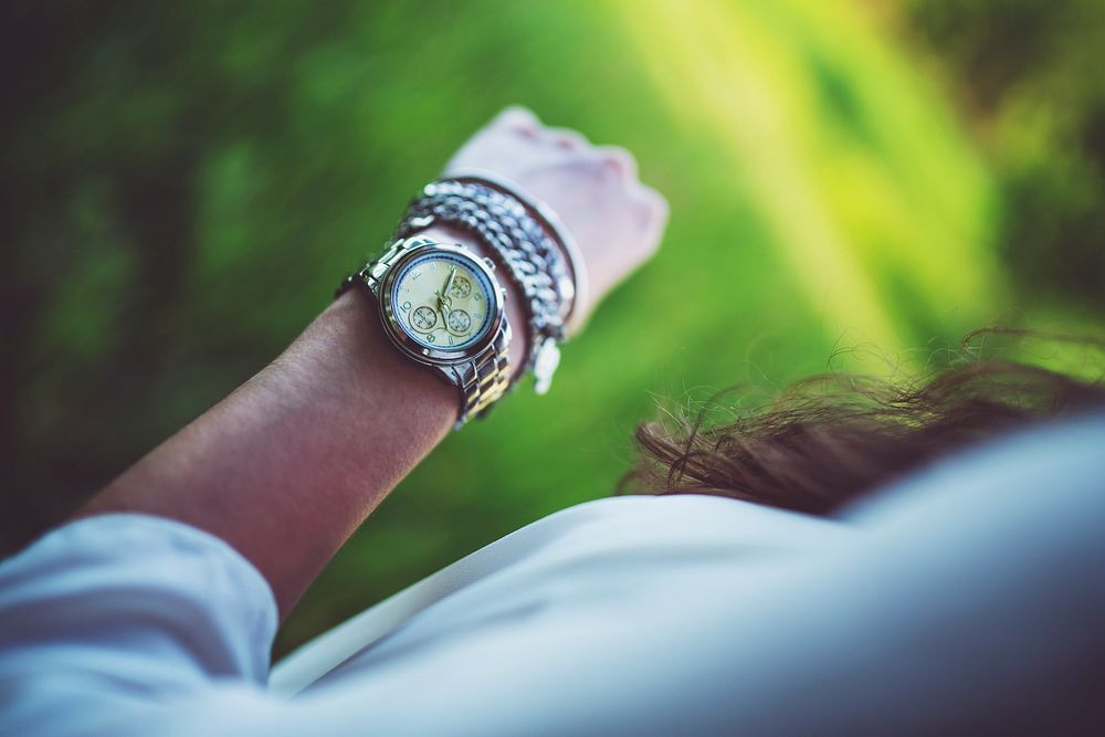 Woman checking her watch. Visit Kaboompics for more free images.