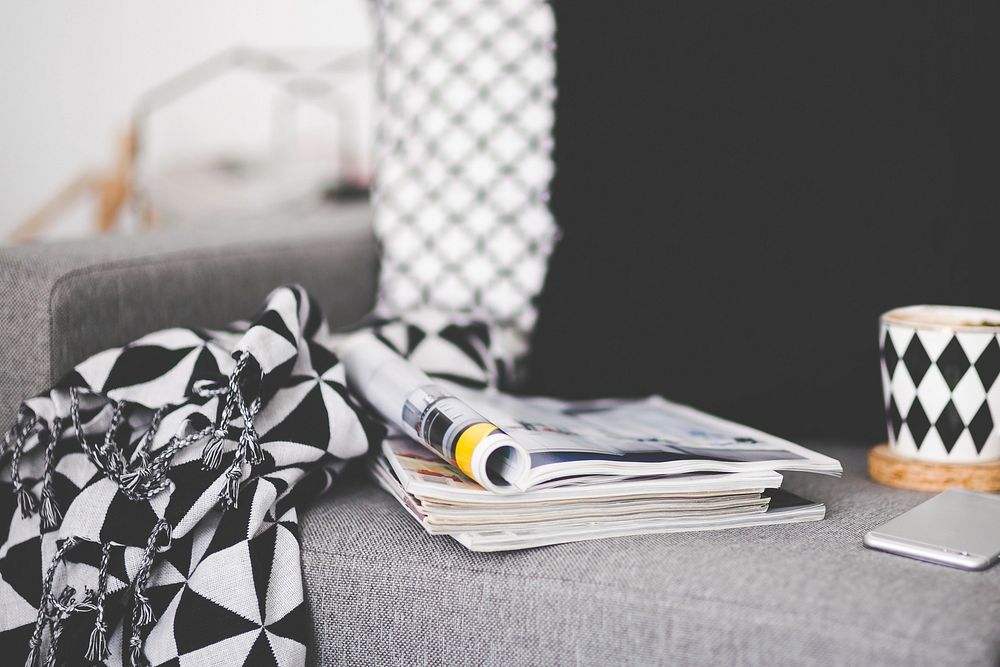 Magazines and a cup of hot chocolate on the couch. Visit Kaboompics for more free images.