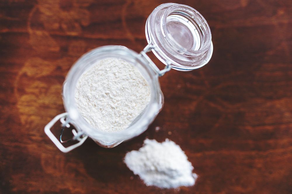 Jar of flour on a table. Visit Kaboompics for more free images.