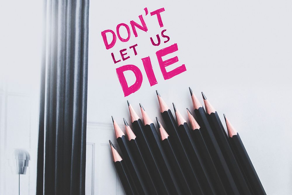 Close up of paper with the phrase "Don't let us die". Visit Kaboompics for more free images.