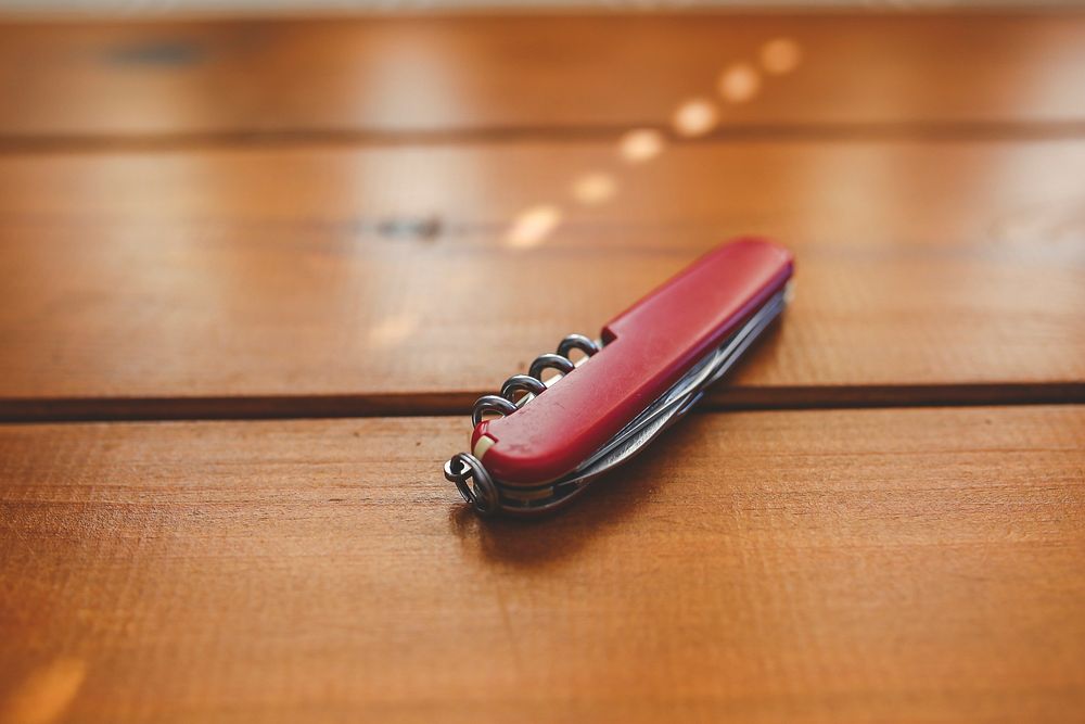 Swiss army knife on a table. Visit Kaboompics for more free images.