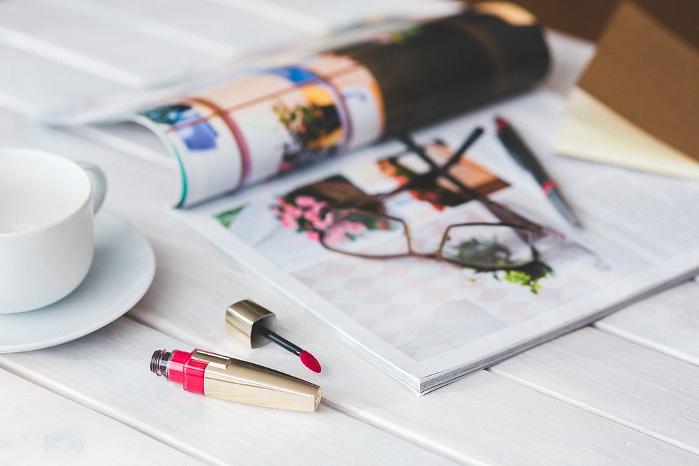 Magazine and makeup on a table. Visit Kaboompics for more free images.
