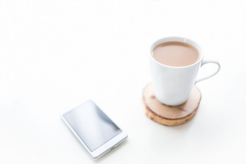 Cup of coffee and a phone. Visit Kaboompics for more free images.
