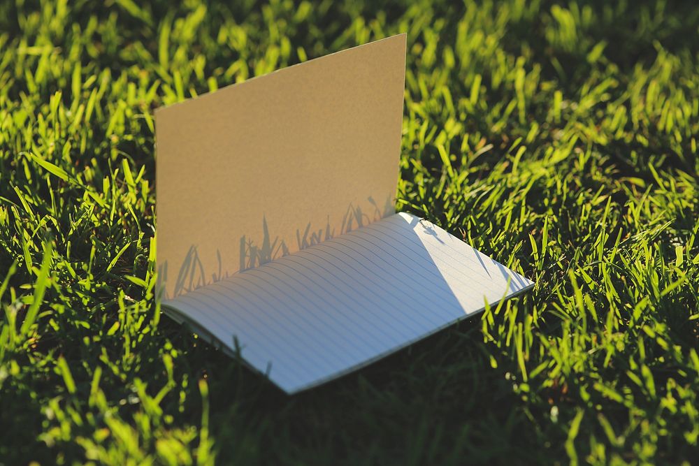 Notebook in the grass. Visit Kaboompics for more free images.