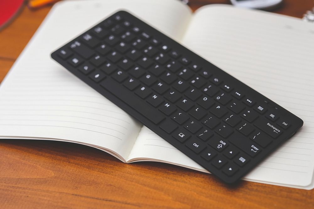 Black keyboard on a notebook. Visit Kaboompics for more free images.