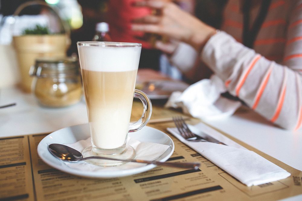 Woman having a latte coffee. Visit Kaboompics for more free images.