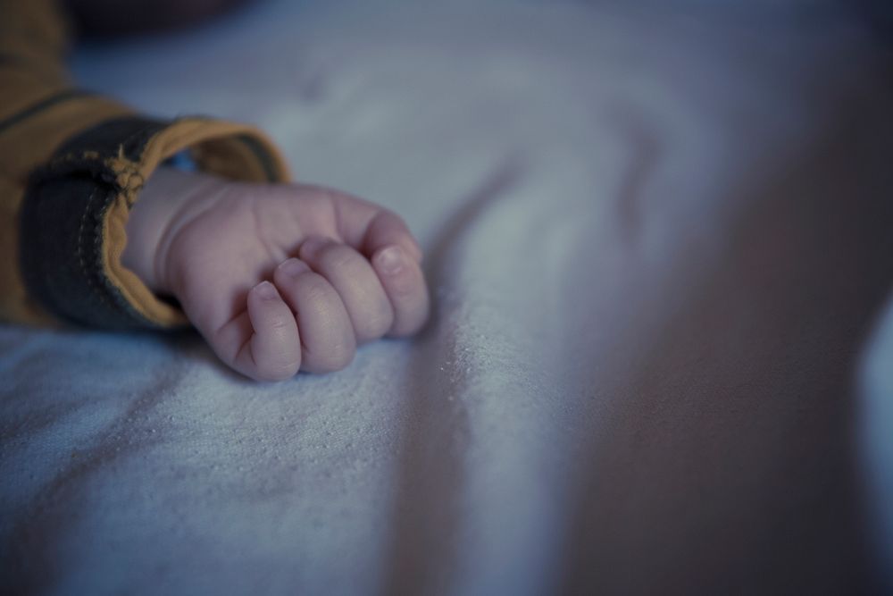 Close up of a child's hand on bed