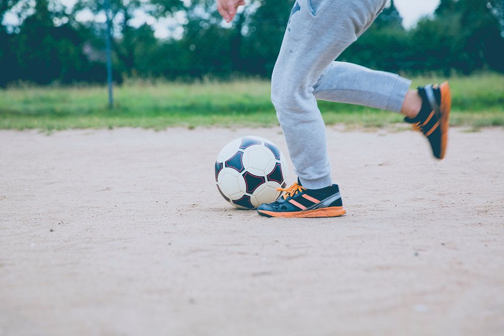 Boy playing football in a soccer field