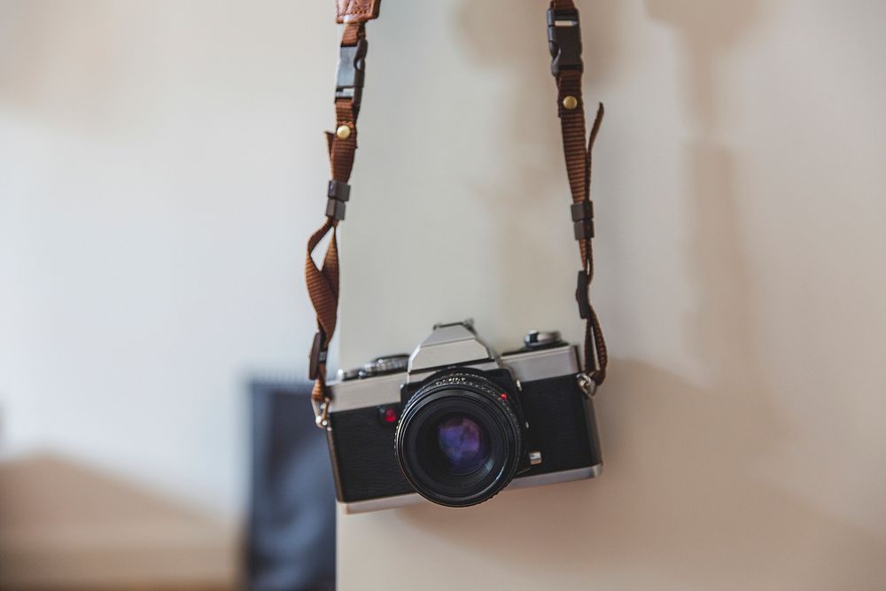 Vintage analog 35mm film camera hanging on a wall