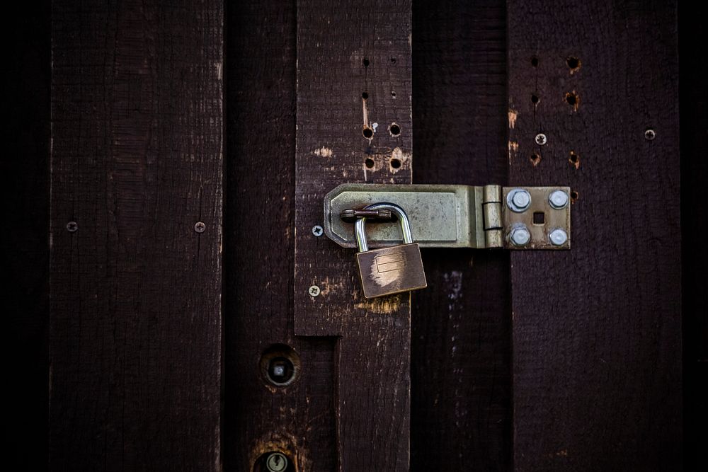 Closeup of padlock on a wooden door
