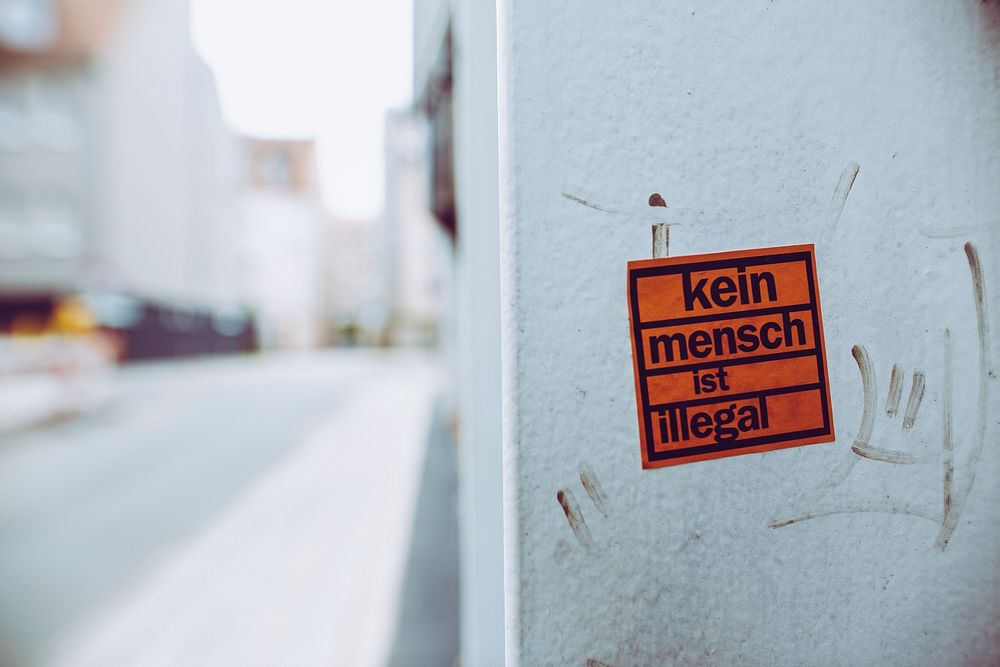 No one is illegal sticker on a white wall